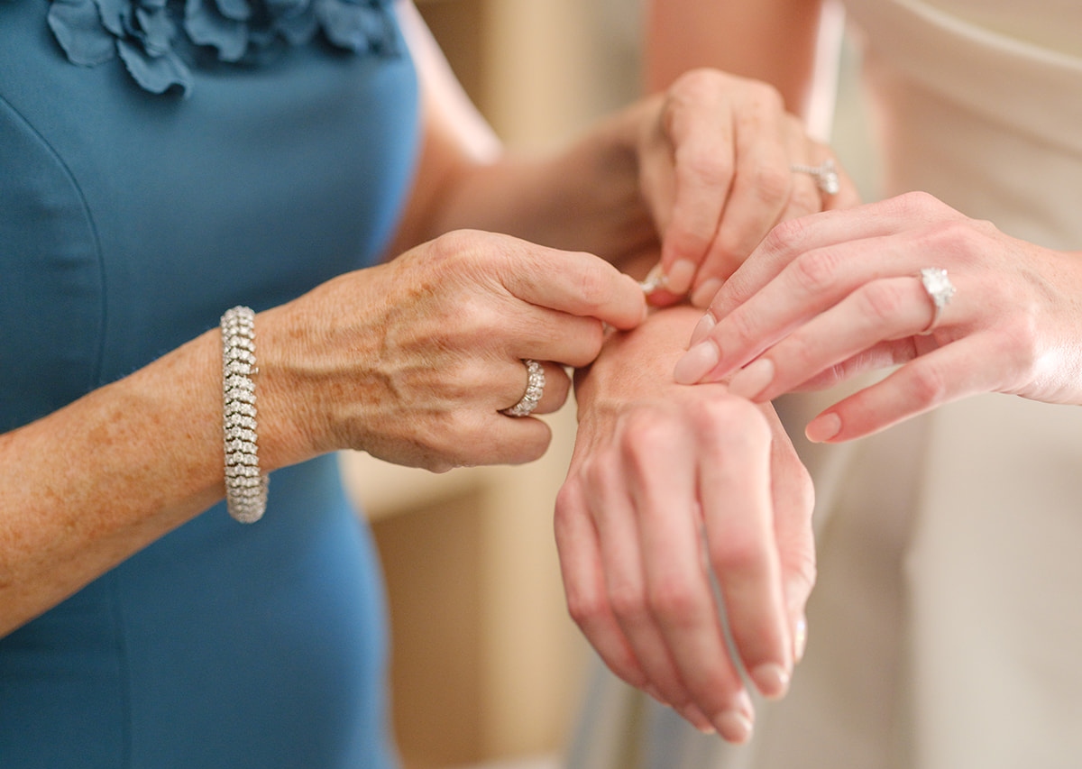 a bride and an older woman looking at their reflection together in a mirror