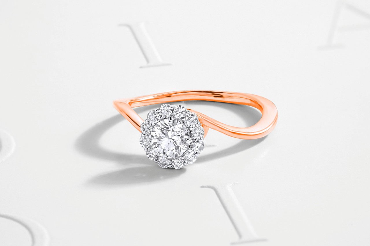 A close-up of a halo ring with a distinctive rose gold band.