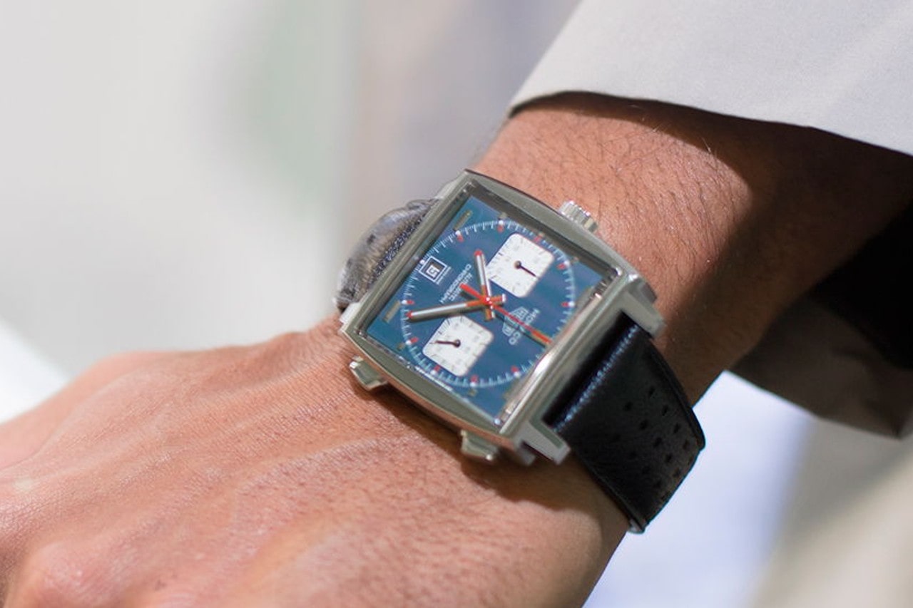 A close-up of a man’s wrist, wearing a TAG Heuer Monaco watch.